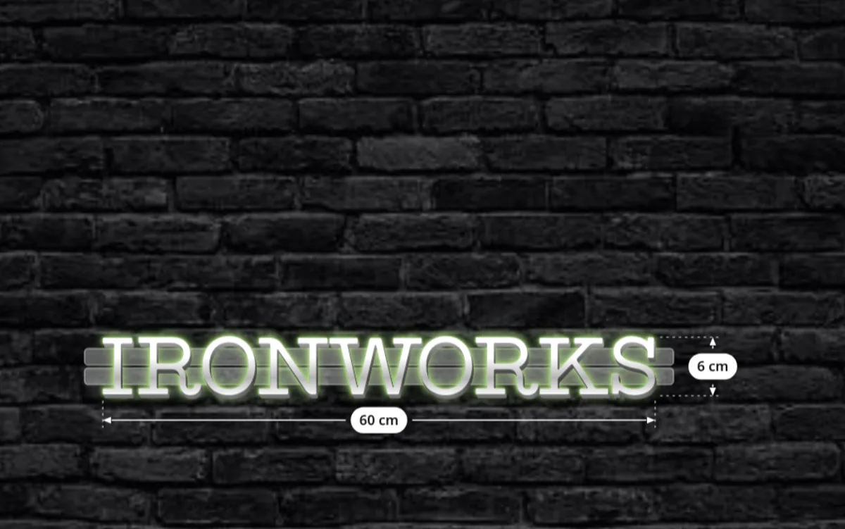 Metal channel letters spelling IRONWORKS on a brick wall with a rectangular backboard